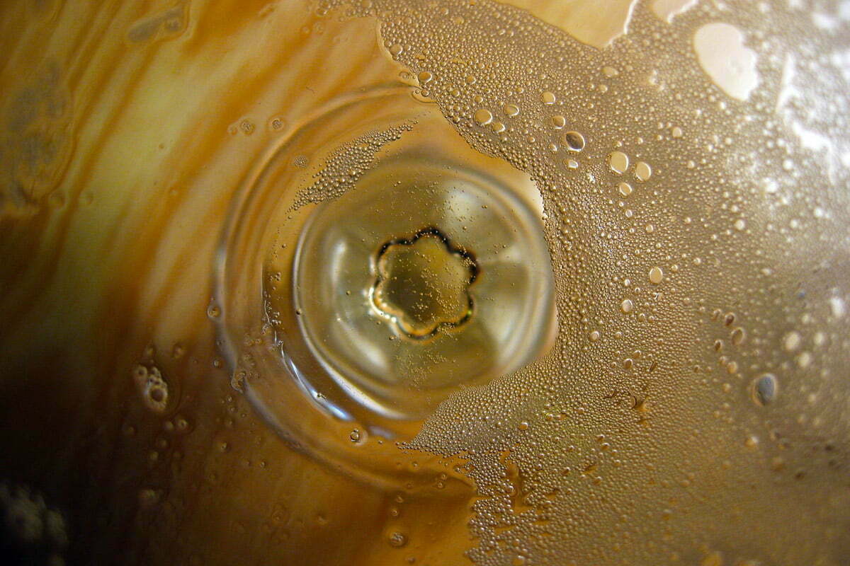Looking down into an empty glass of champagne with small bubbles around the edges.