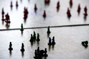 Pieces of a Risk board game with a heavy reflection.