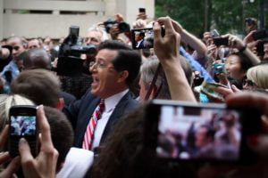 Steven Colbert is surrounded by cameras as he leaves Washington DC