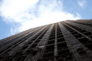 A view up the facade of a San Francisco facade at the clouds, sun and sky above.