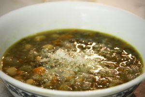 A bowl of homemade lentil soup with some parmesan sprinkled on top.