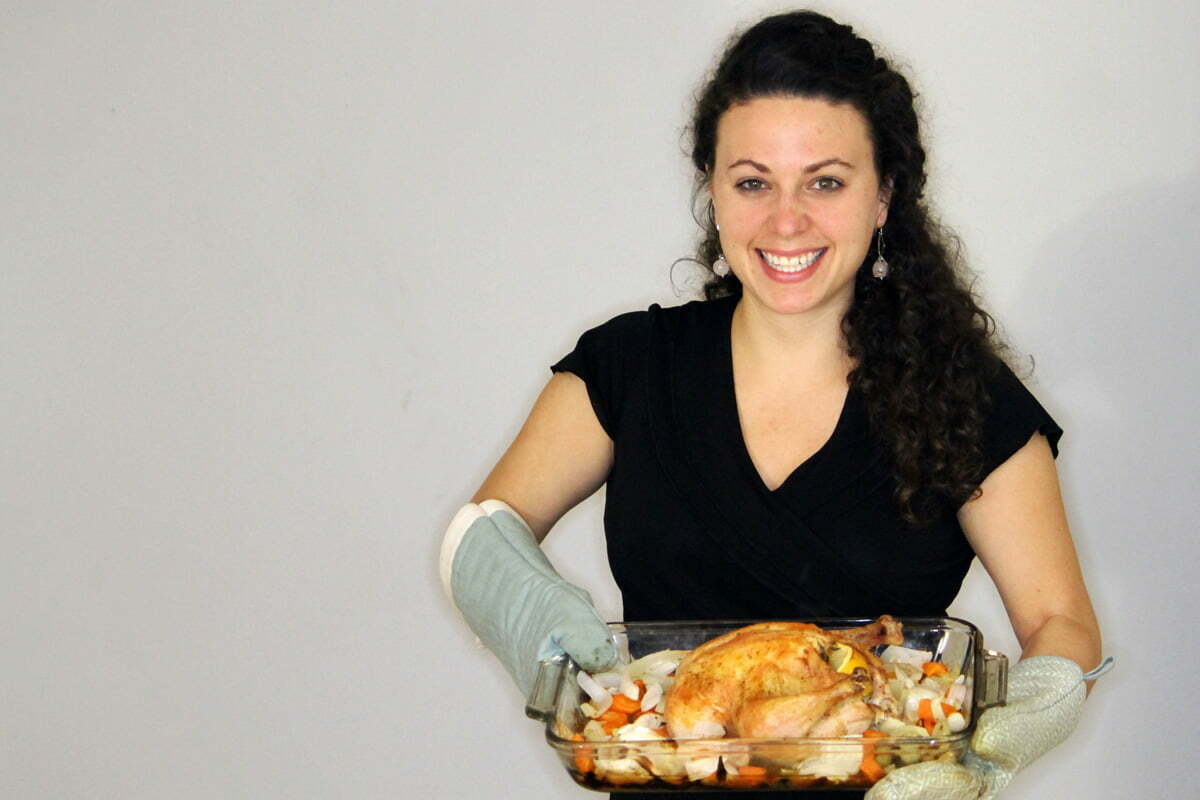 Sally holds the roast chicken with vegetables.