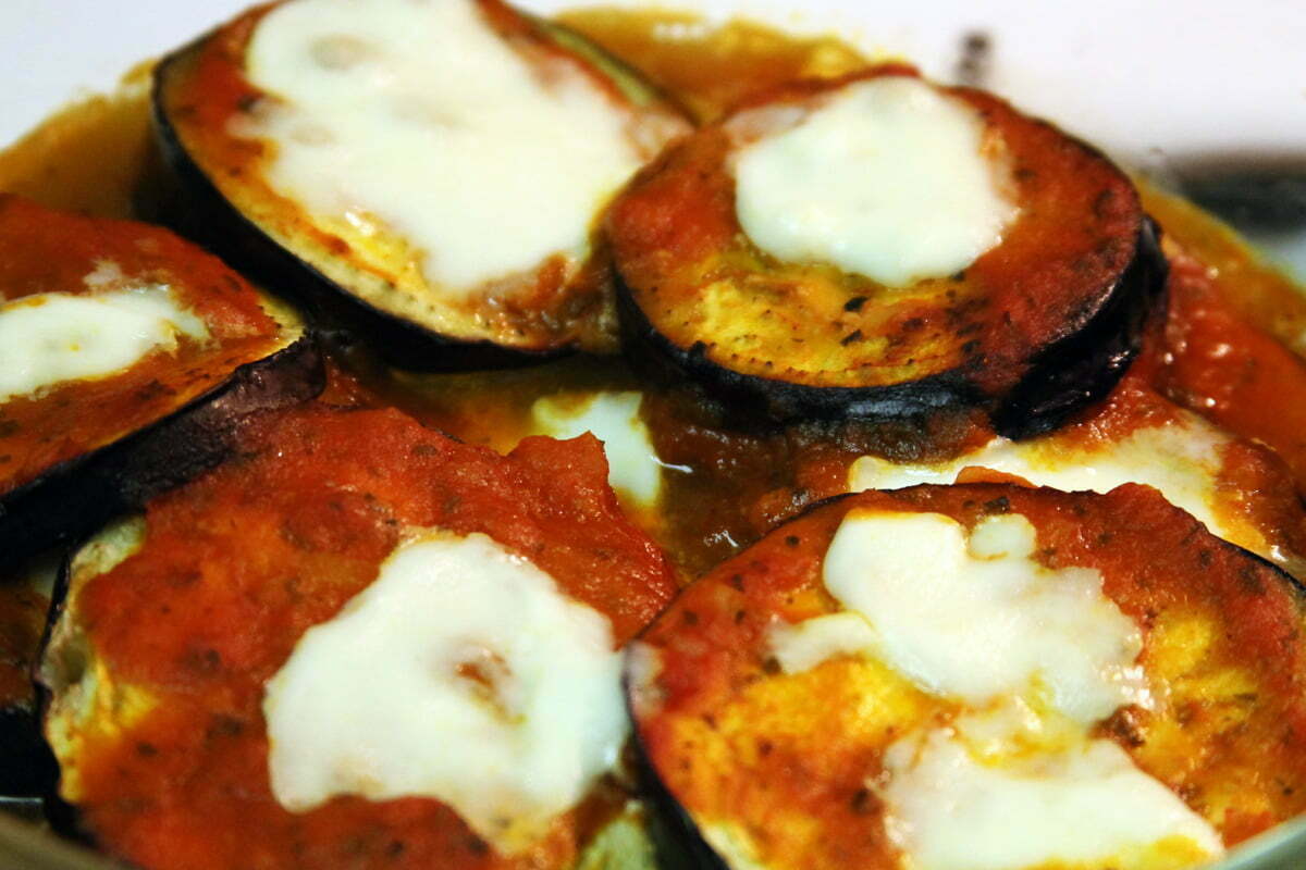 The fully baked eggplant slices finish topped with hot mozzarella cheese and tomato sauce.