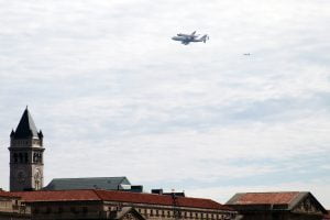 The space shuttle Discovery flying over the Old Post Office Building in Washington DC.