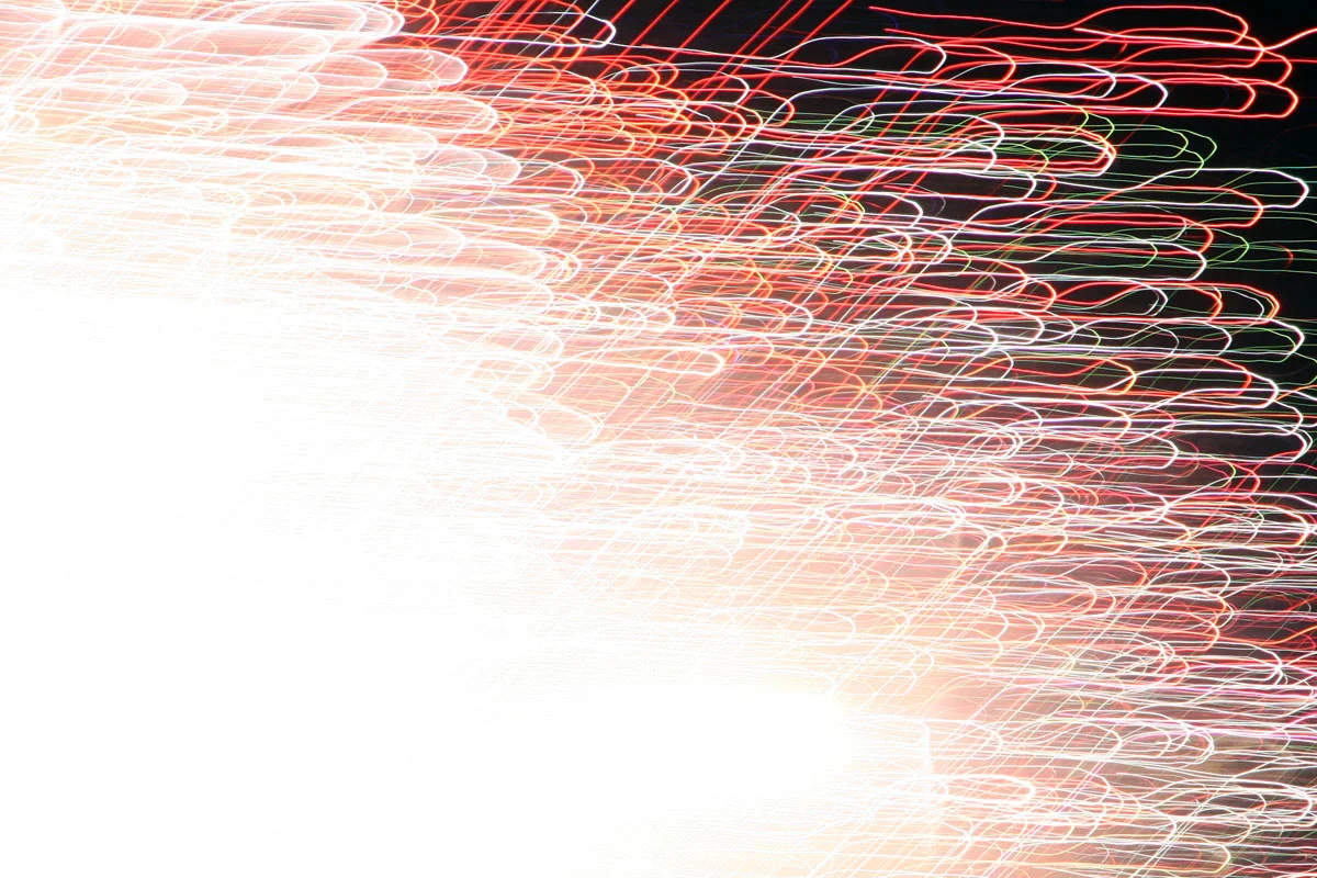 A long exposure photograph of fireworks with blurry colorful lines going in many directions.
