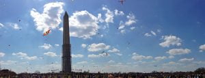 A panorama of kites in the air and the crowds near the Washington Monument at the annual Cherry Blossom Kite Festival on the National Mall in Washington D.C.