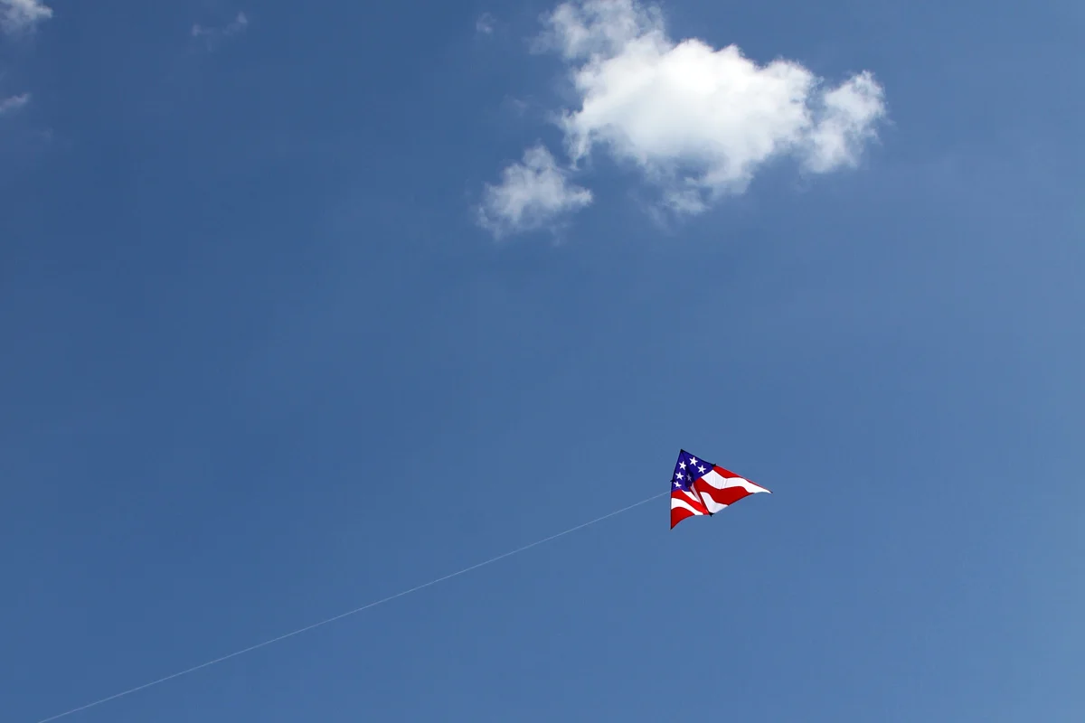 A large and solitary American flag kite flies at the Cherry Blossom Kite Festival near the Washington Monument in Washington D.C.