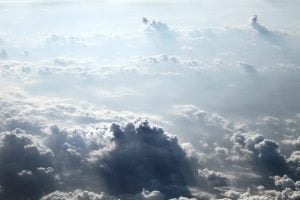 Blue and white cumulus clouds seen from above in a plane.