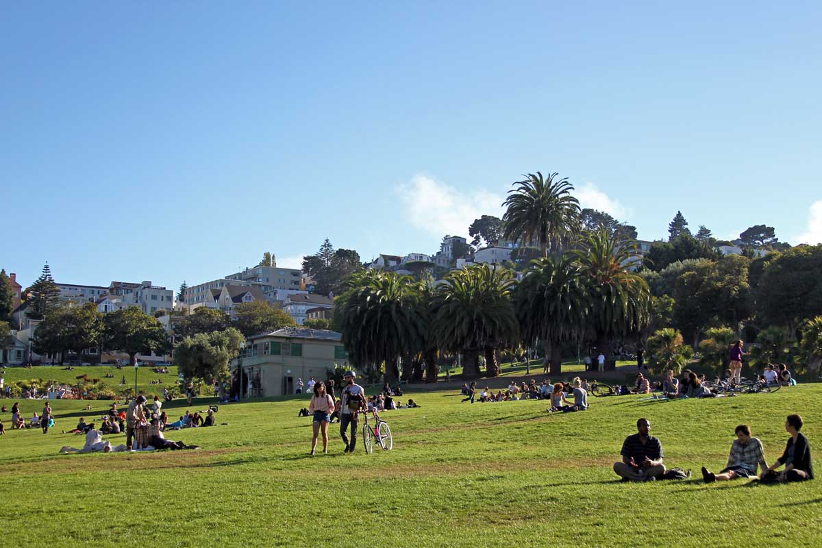 People relax on the green grass at Dolores Park in San Francisco.