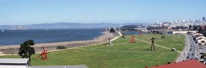 A panorama taken from over Crissy Field that shows Alcatraz on the far left and the buildings of downtown San Francisco on the right.