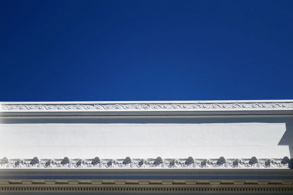 Blue sky against the top portion of the Internet Archive building with the text from the former Fourth Church of Christ, Scientist church white washed out in San Francisco.