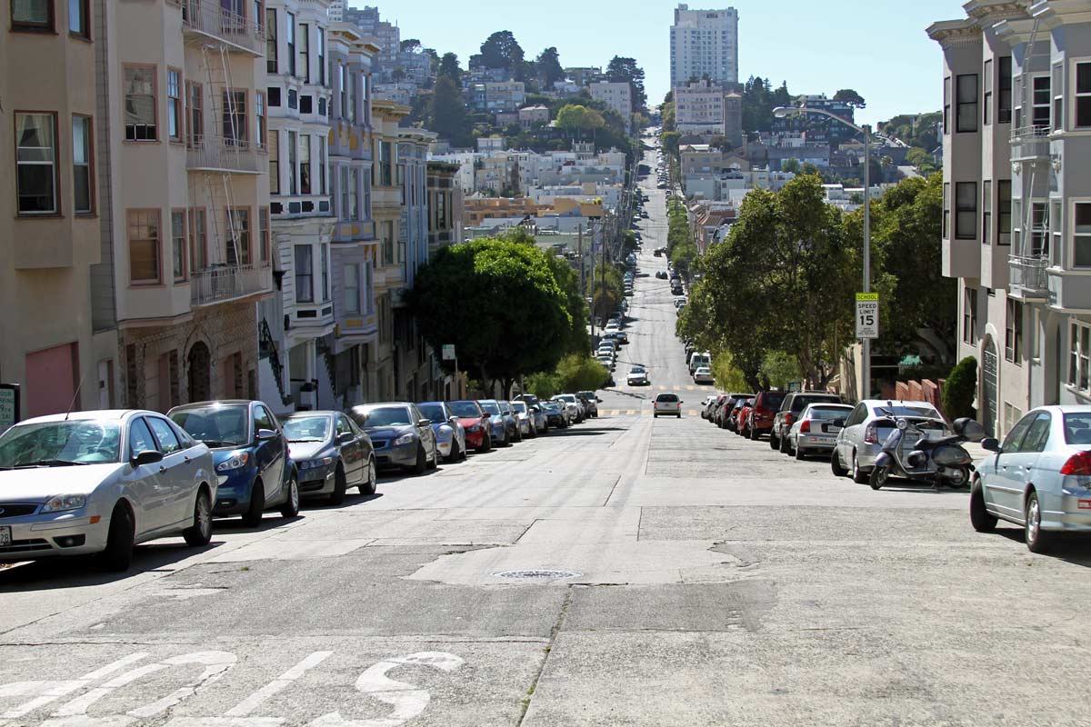 The view down the center of a steep street in San Francisco, California.