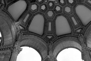 A black and white photo of statues and ornate ceiling of the rotunda at the Palace of Fine Arts in San Francisco, California.