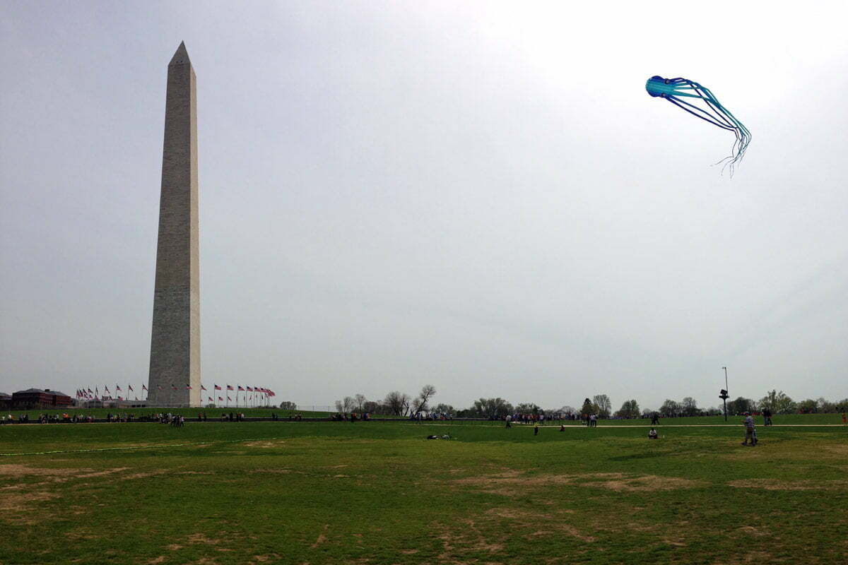 A large blue and white octopus kite flies near the Washington Monument at the National Mall in Washington DC.