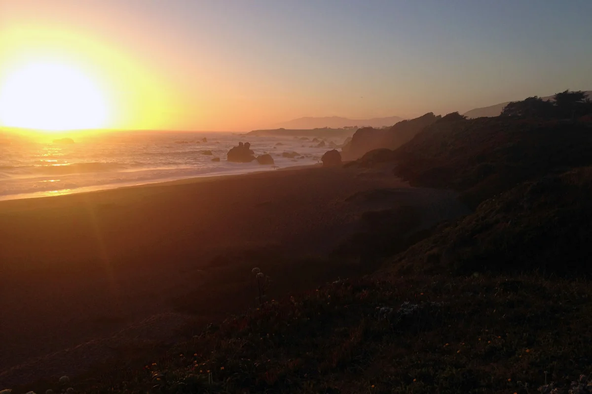 A sunset over the Pacific Ocean along the beach and rocks out in waters of Bodega Bay at Sonoma, California.