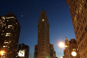 The iconic Flatiron Building in New York City seen as night falls.