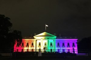 A photo of the White House illuminated with Rainbow Flag colored lights in honor of the Supreme Court decision supporting gay rights and marriage.