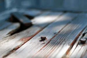 A hex screw in a weather worn, old wood table.