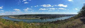 A panoramic photo taken on a cloudy day with blue skys over the Ohio River looking towards Kentucky from Cincinnati.