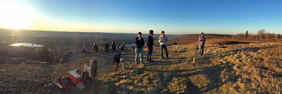A group of friends hang out on a mountaintop to watch the sun setting in Canaan Valley, West Virginia.