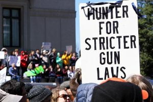 A man holds up a sign that says 'Hunter for Stricter Gun Laws' at the March for Our Lives in Washington DC.